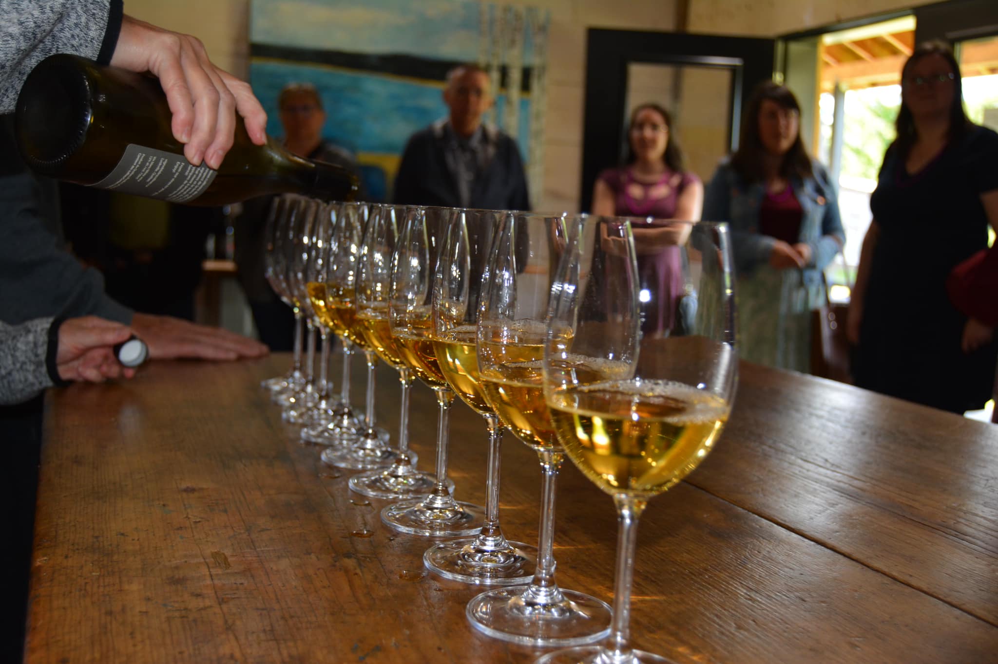 Dans la salle d'accueil, l'hôte remplit les coupes de vin pour la dégustation.